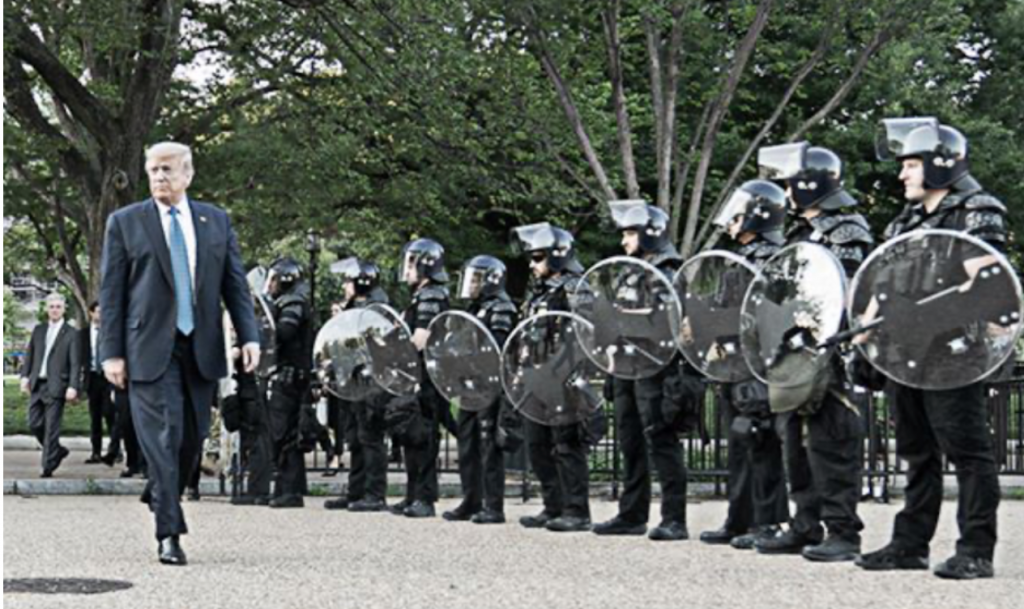 Body of ad by Biden. The ad shows Trump walking by a line of armed security forces.