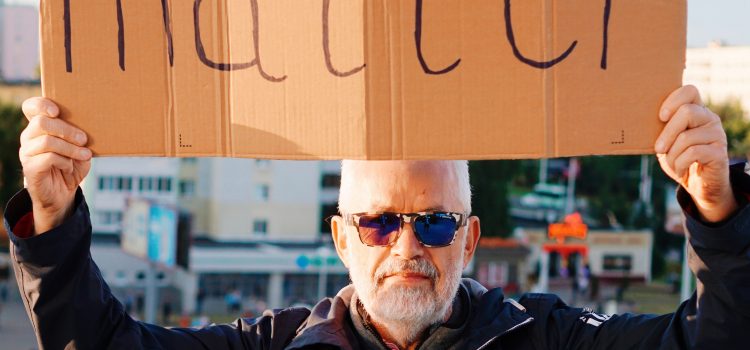 Person holding cardboard sign reading "Our votes matter."